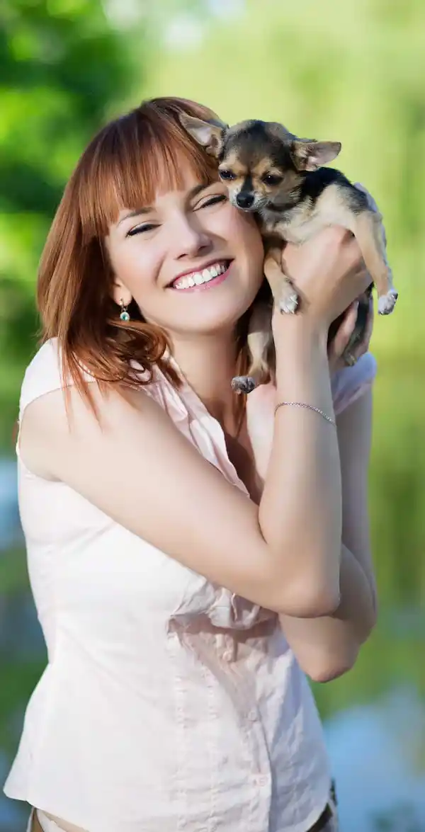 Jeune fille souriante caressant un chien, travail de garde d'animaux trouvé sur Askaide.com