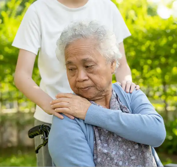 Dame s'occupant d'une personne âgée en fauteuil roulant, emploi de soignant pour seniors trouvé sur Askaide.com