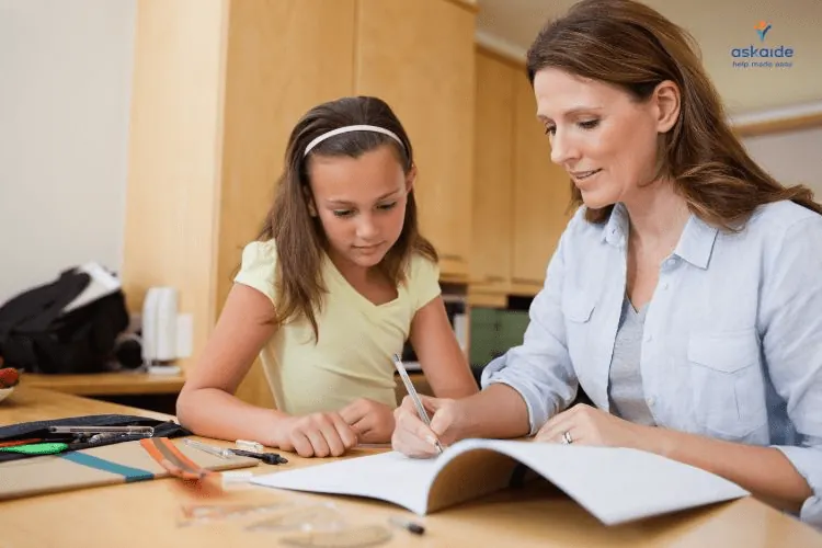 Oudere vrouw, mogelijk een lerares, helpt een kind met huiswerk